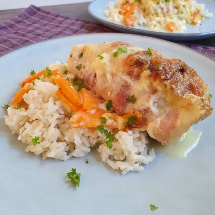 Kylling med bacon og flødesovs serveret med ris